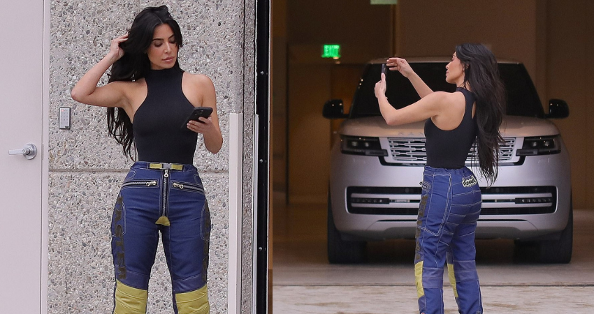 Kim Kardashian shows off her famous curves in a pair of figure-hugging jeans while outside her office to take a phone call in Calabasas