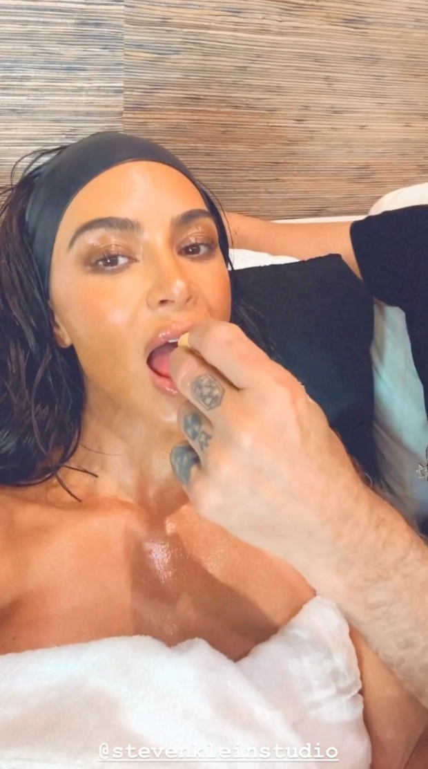 SO MUCH SKKN Kim Kardashian goes naked in just a towel and shows off oiled-up skin as she’s hand-fed by mystery man in steamy video