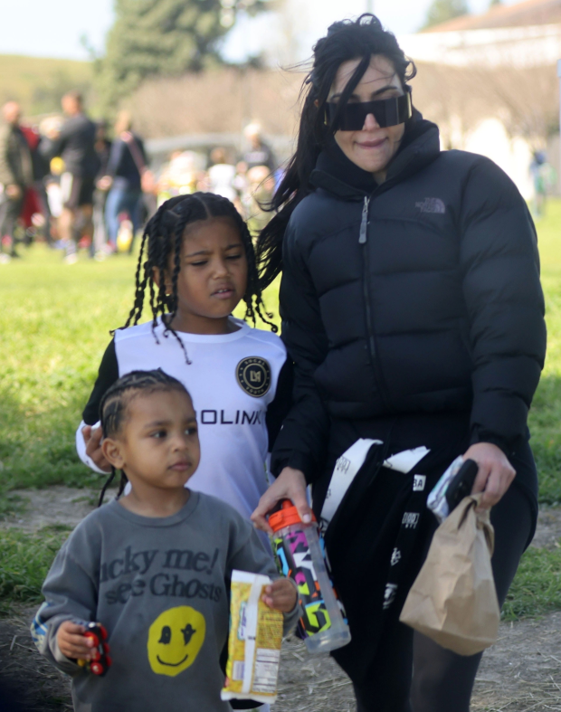 SOCCER MOM Kim Kardashian shows off her real skin and ditches designer clothes for socks with sandals at Saint’s soccer game