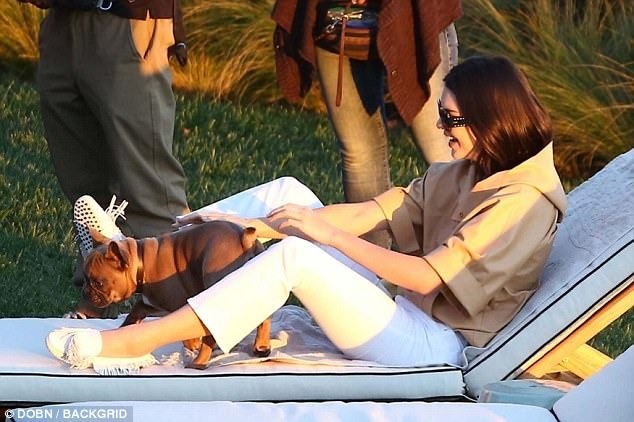 Now that’s a fun day at work! Kendall Jenner puts on a playful display with a puppy before being swung around by a shirtless hunk as she films on a beach in Malibu