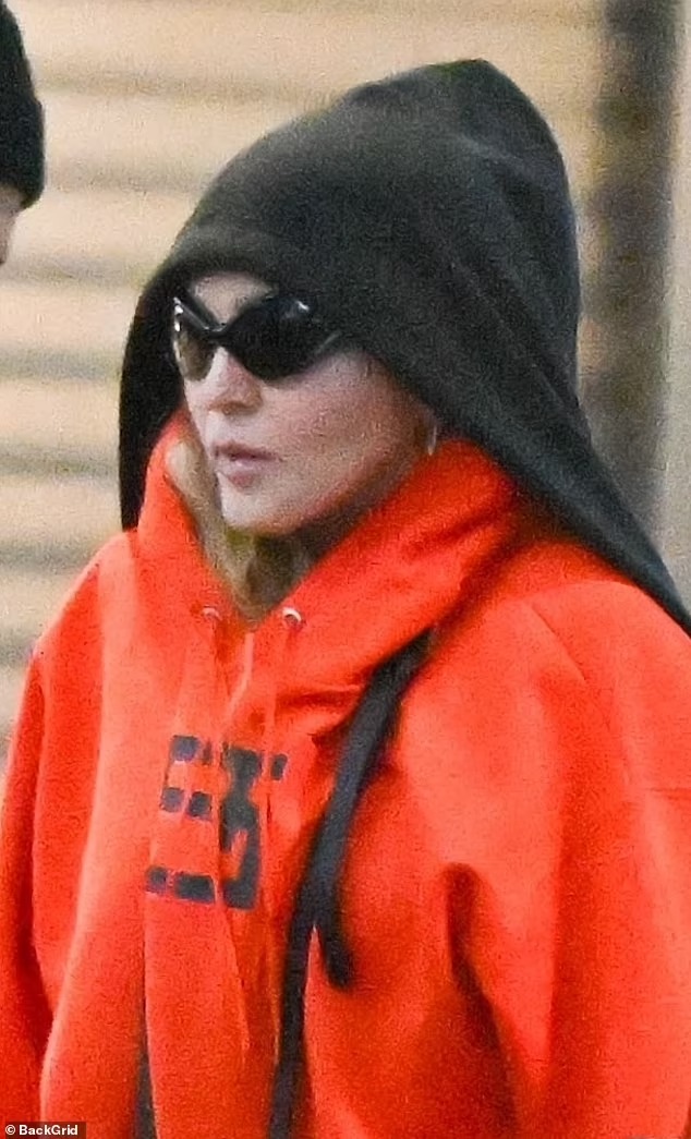 Madonna goes make-up free in baggy sweats at JFK Airport to fly to England 10 days ahead of her Celebration Tour