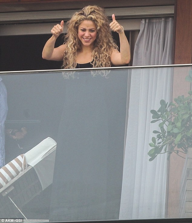 Two thumbs up! Shakira gives adoring fans in Brazil universal sign of approval and blows kisses from H๏τel room balcony