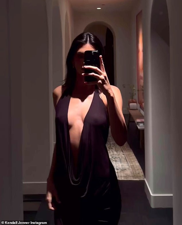 Kendall Jenner sizzles in plunging black dress as she shows off her model physique in new video during Aspen getaway with sisters Kim and Khloe